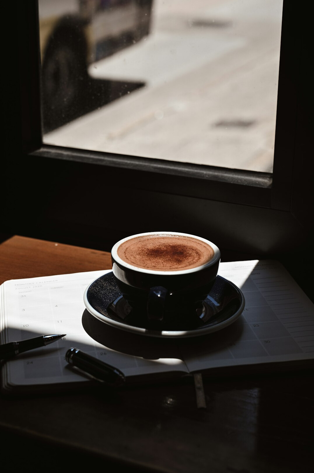 Detective notebook with pen and cup of coffee on desk