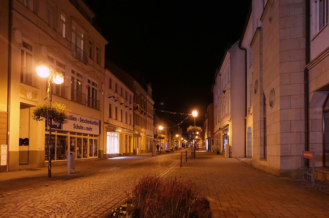 Empty cobblestone street at night under streetlights